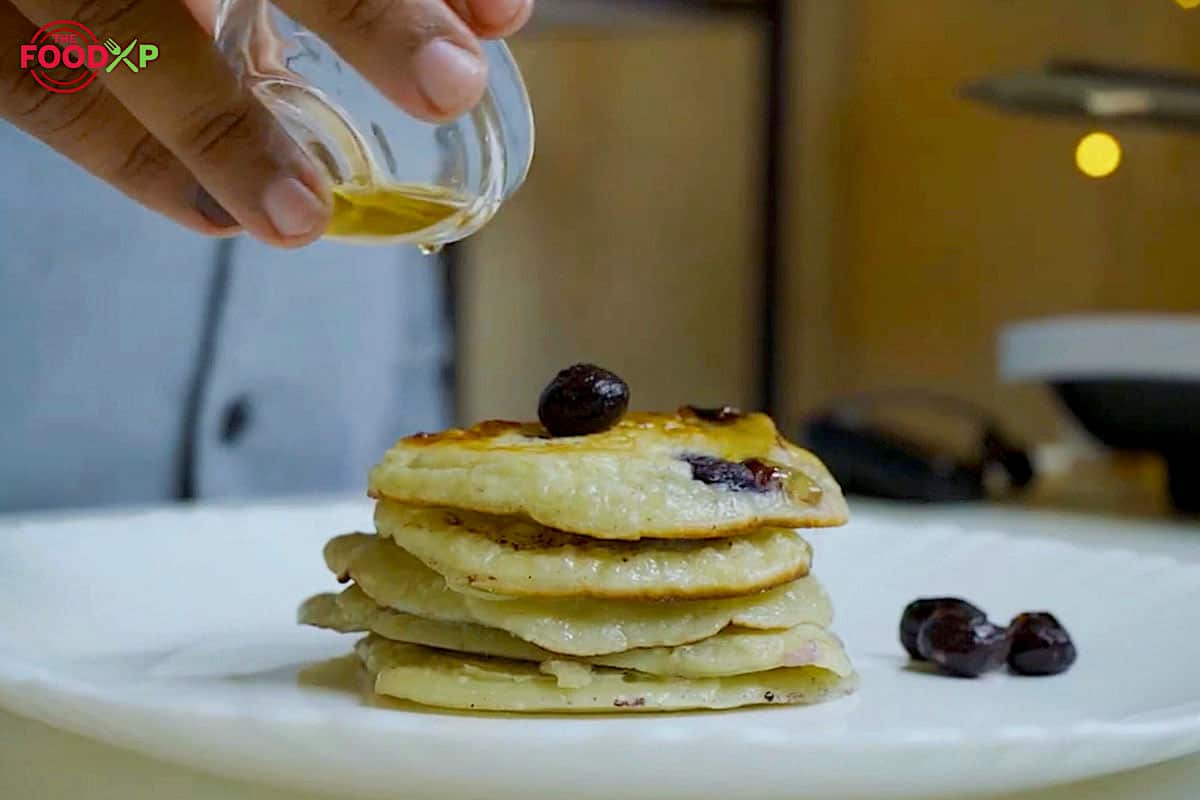 Honey drizzling over Gordon Ramsay Blueberry Pancakes